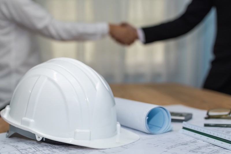 Safety Helmet And Building Plans On The Table